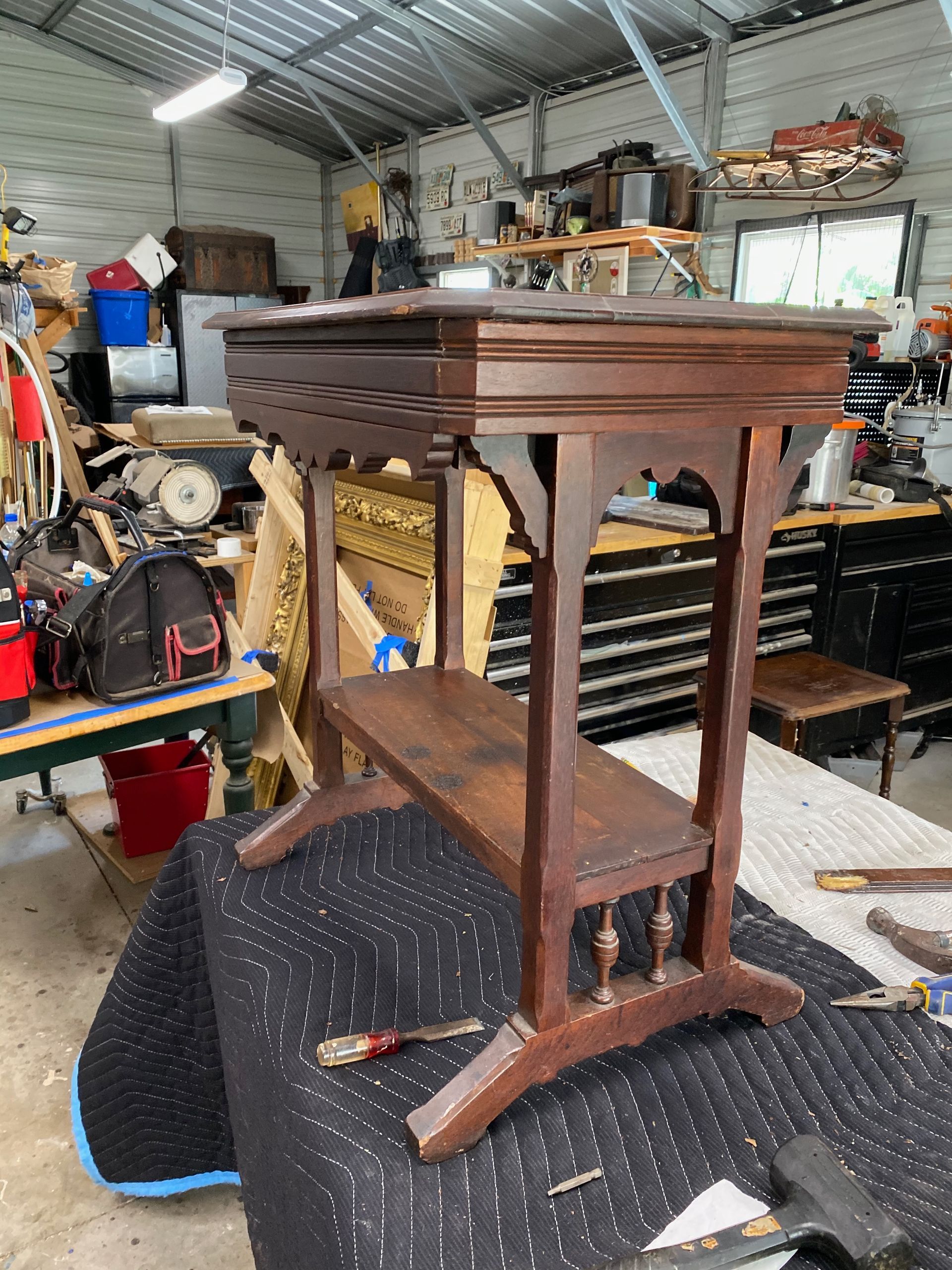 A small wooden table is sitting on top of a table in a workshop.
