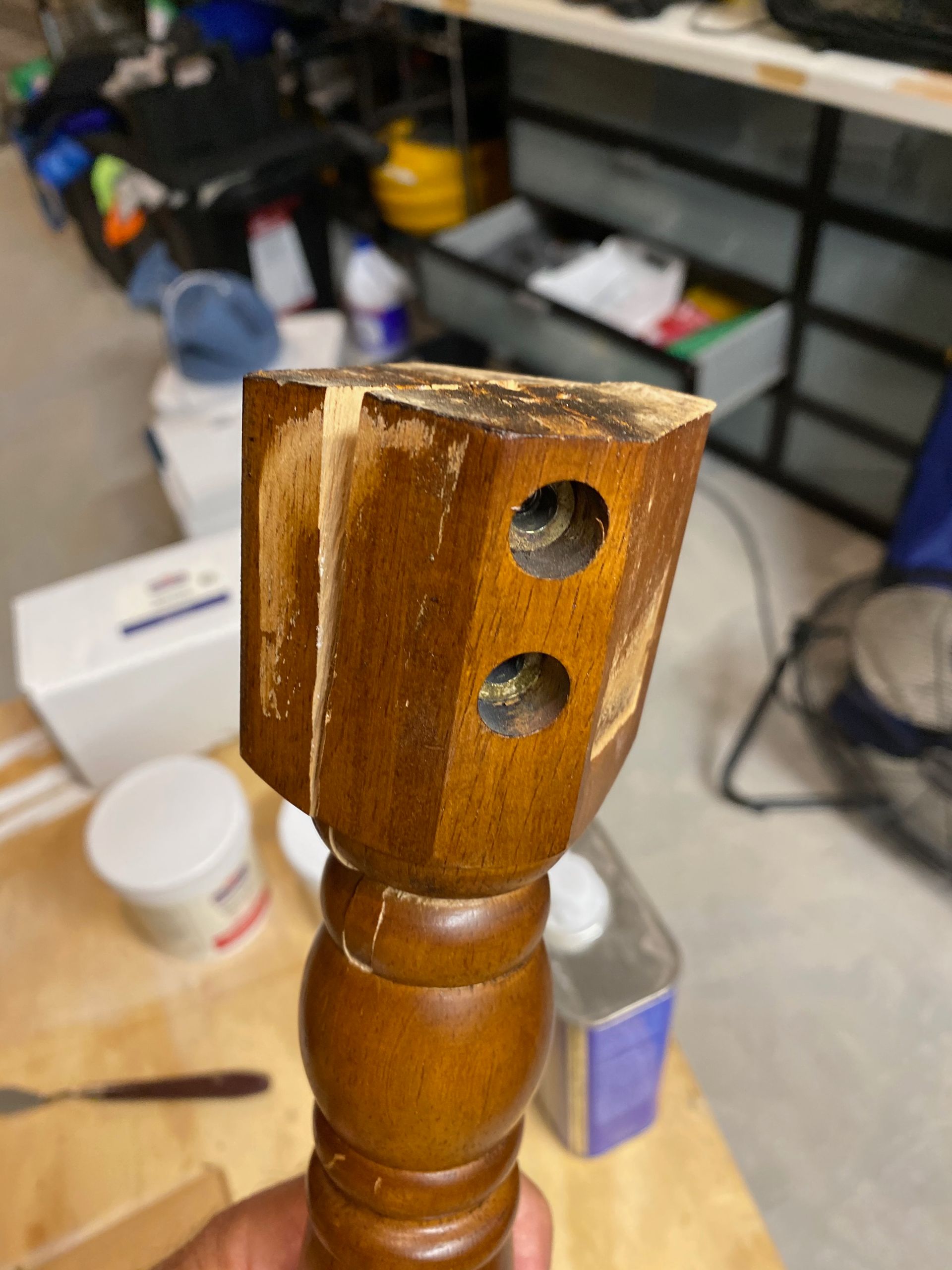 A person is holding a piece of wood with two holes in it.