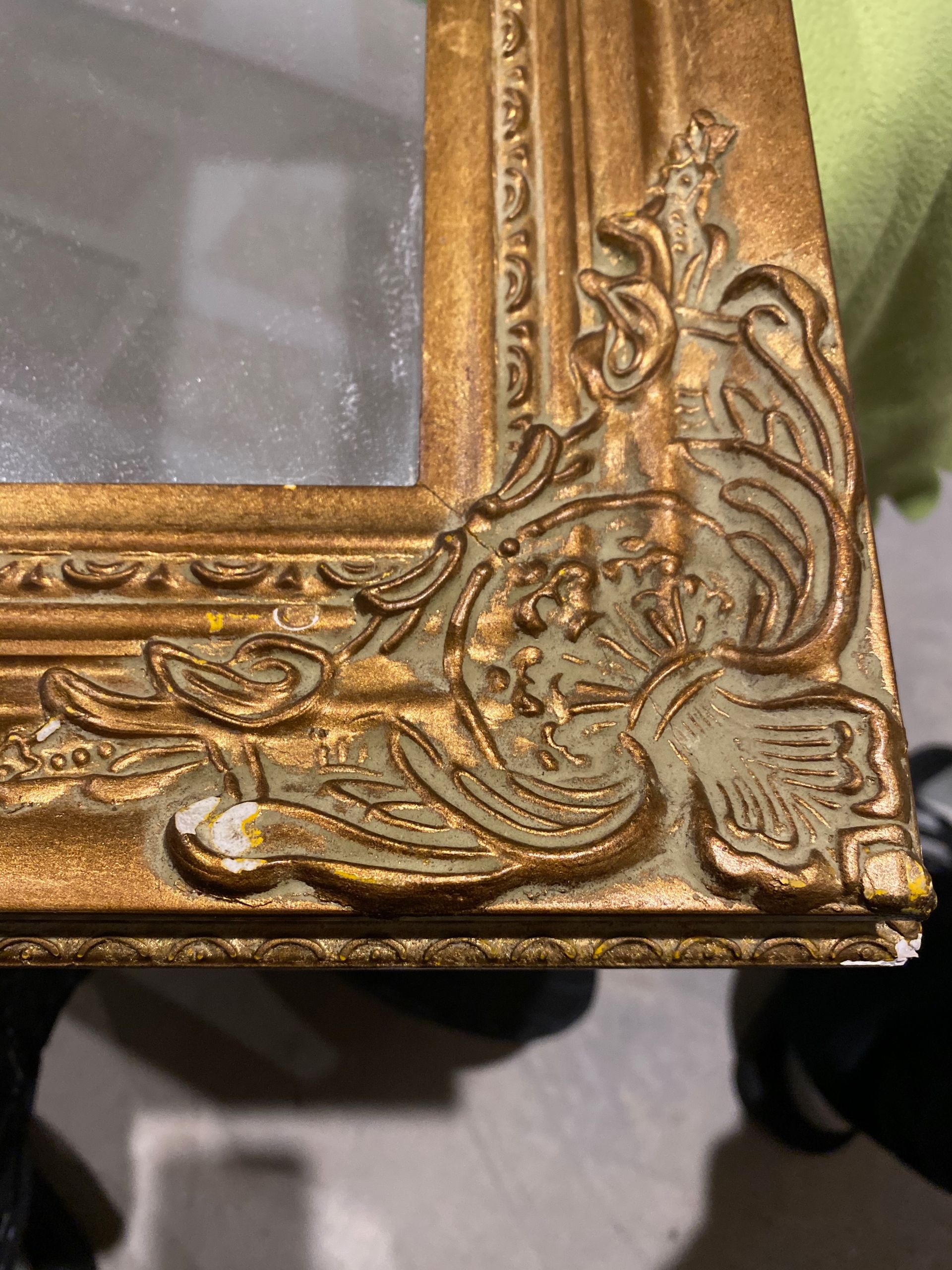 A close-up of the corner of a gold frame.