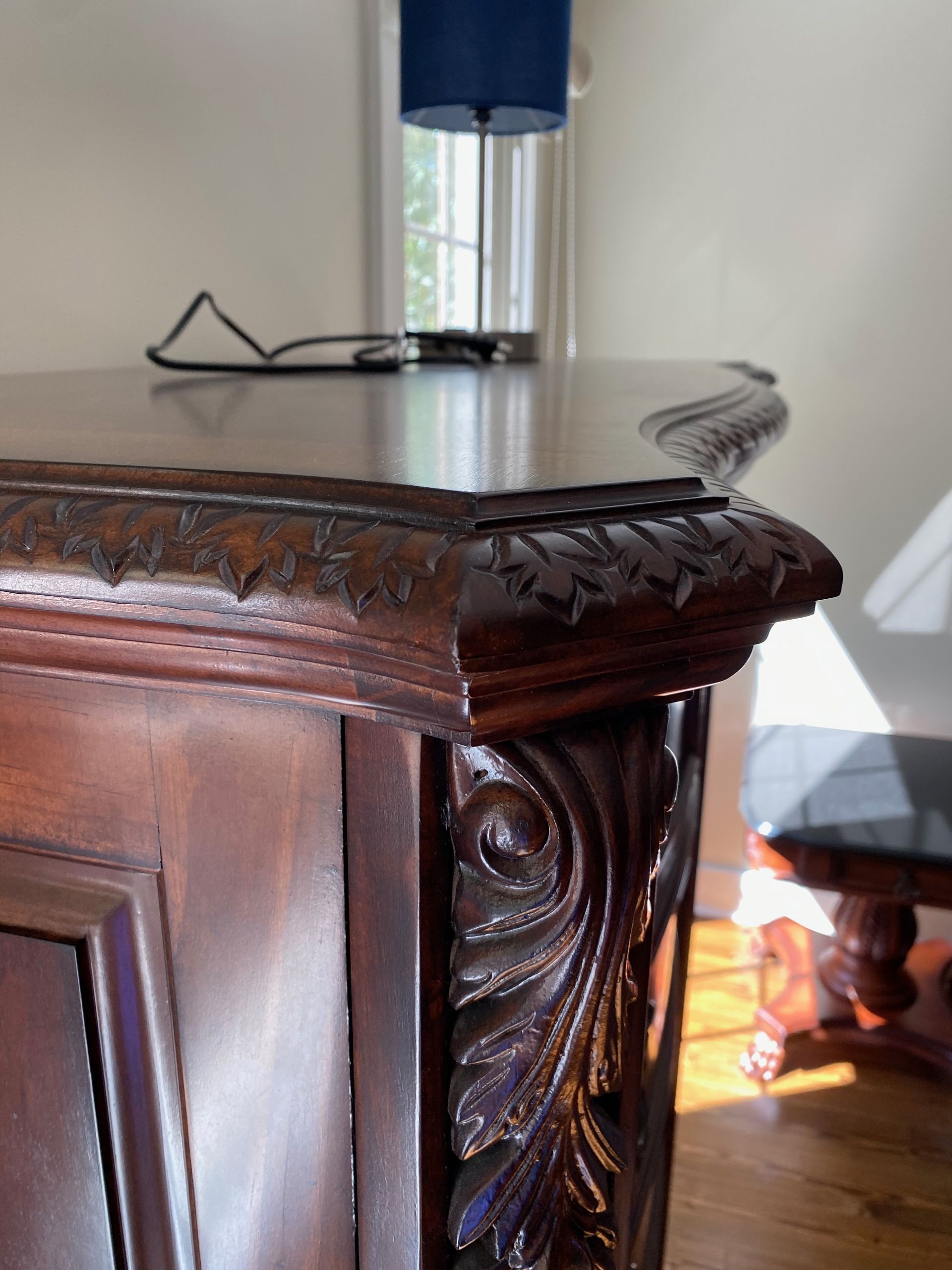 A wooden table with a lamp and glasses on it