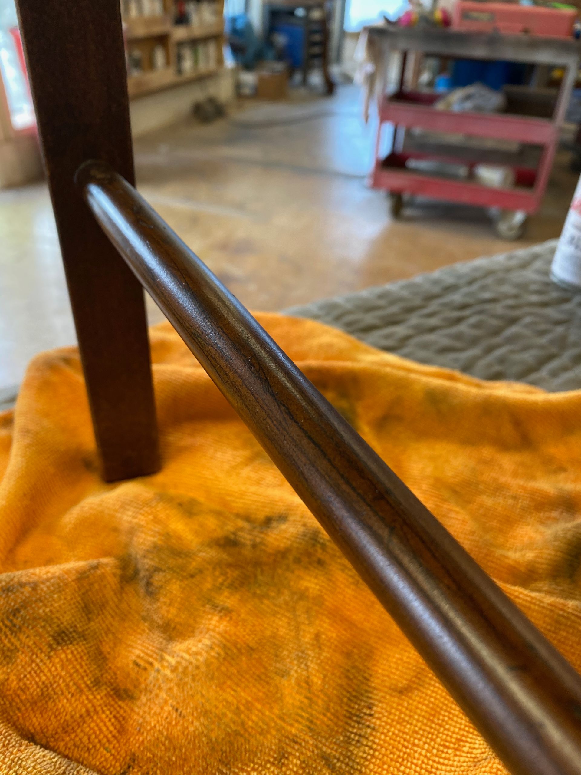 A wooden pole is sitting on top of a yellow towel.