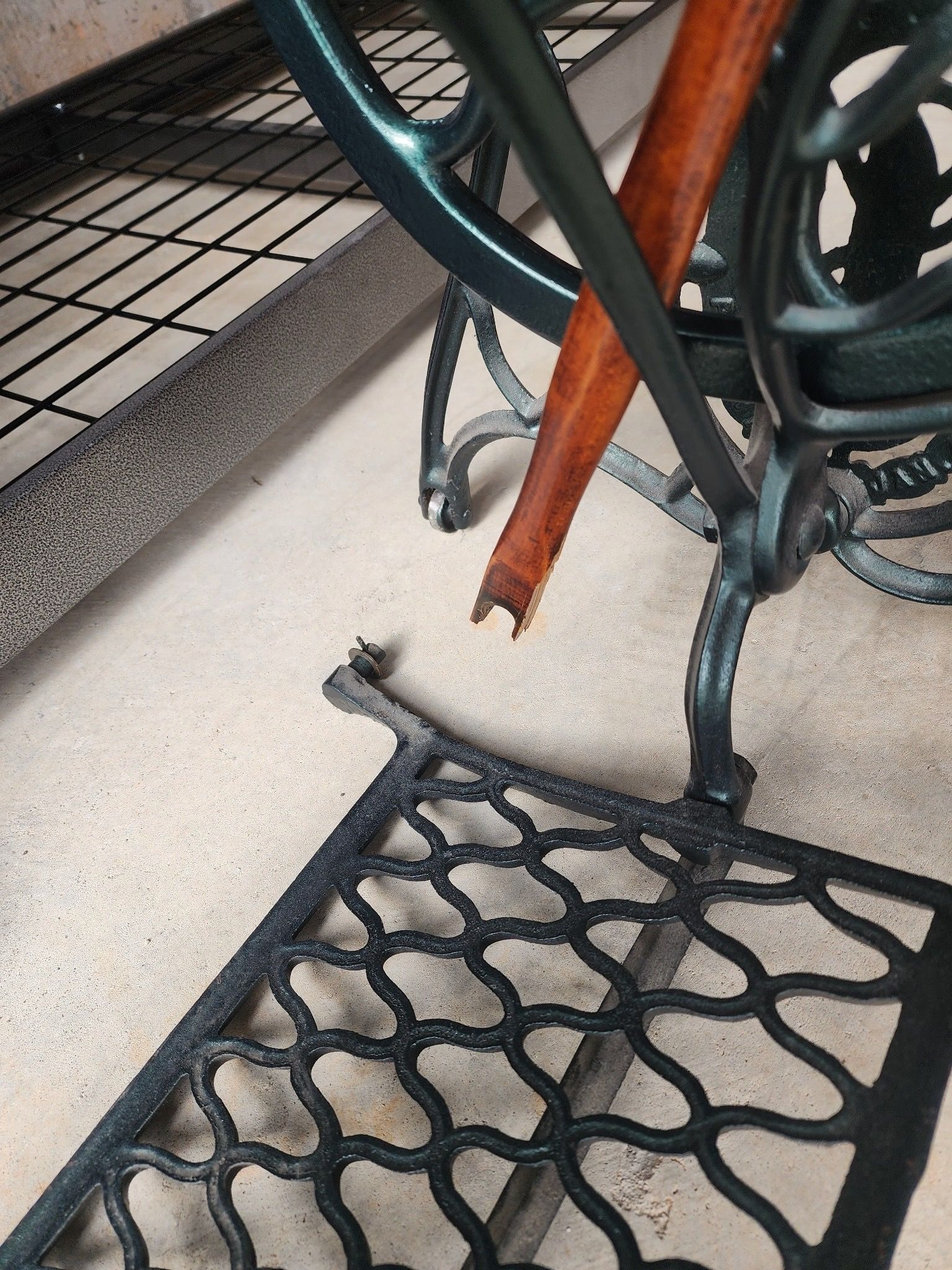 A close-up of a sewing machine with a broken leg