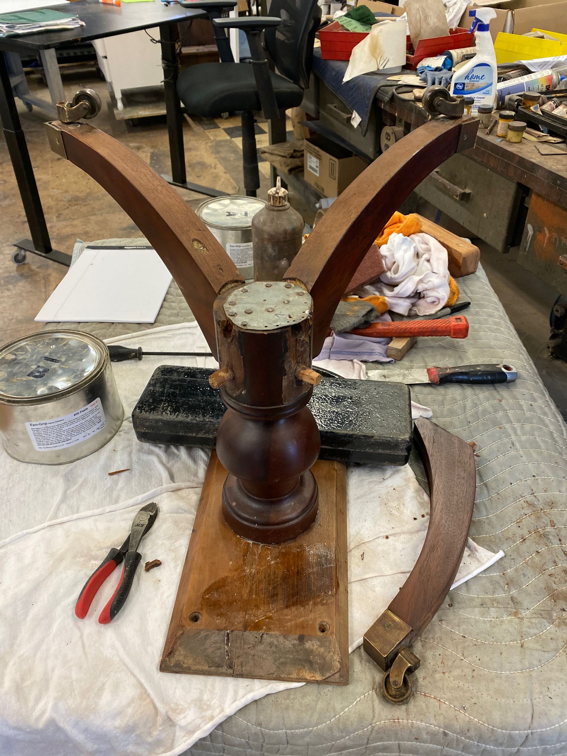 A piece of wood is sitting on a table next to a pair of pliers.