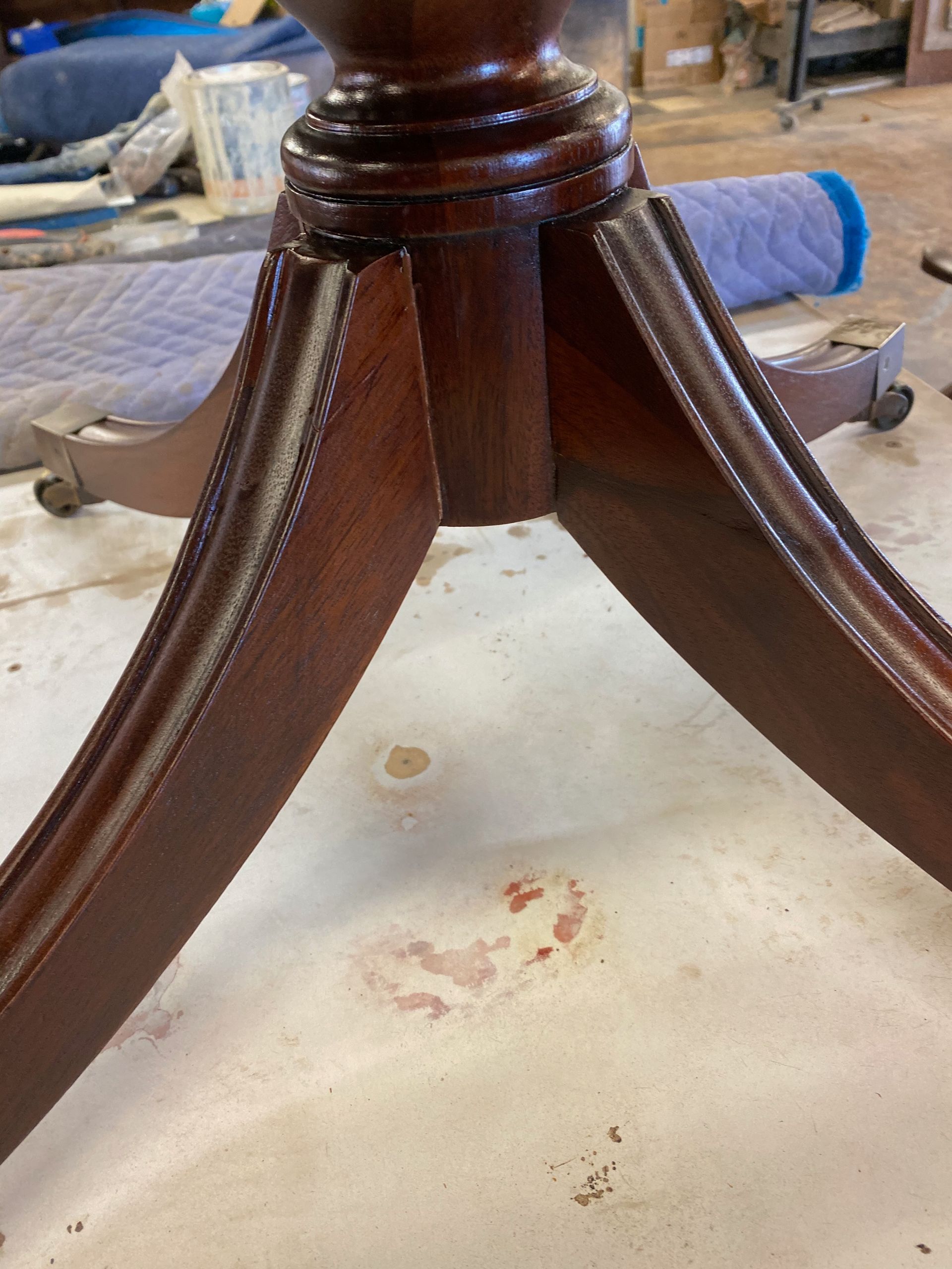 A close-up of a wooden table with a stain on the floor