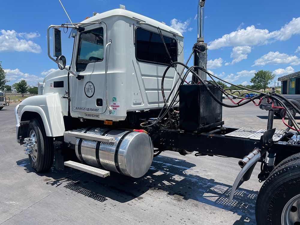 A white semi truck is parked in a parking lot.