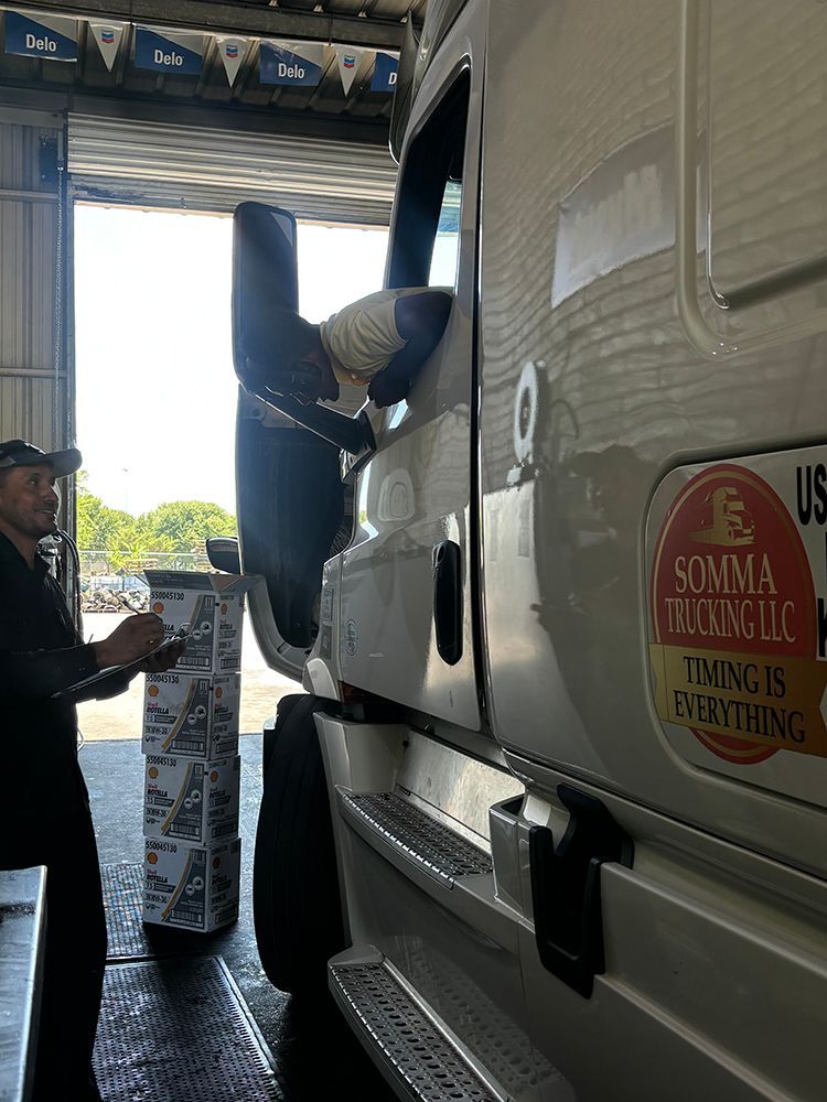 A man is working on a semi truck in a garage.