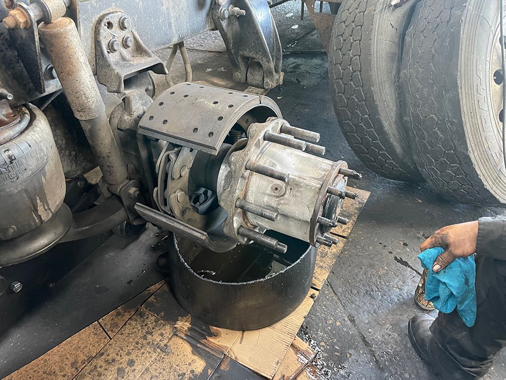 A person is working on a truck in a garage.