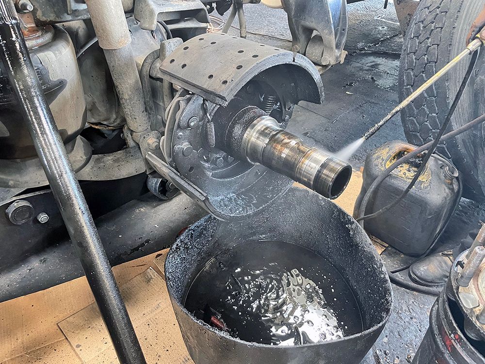 A bucket of oil is being poured into a machine.