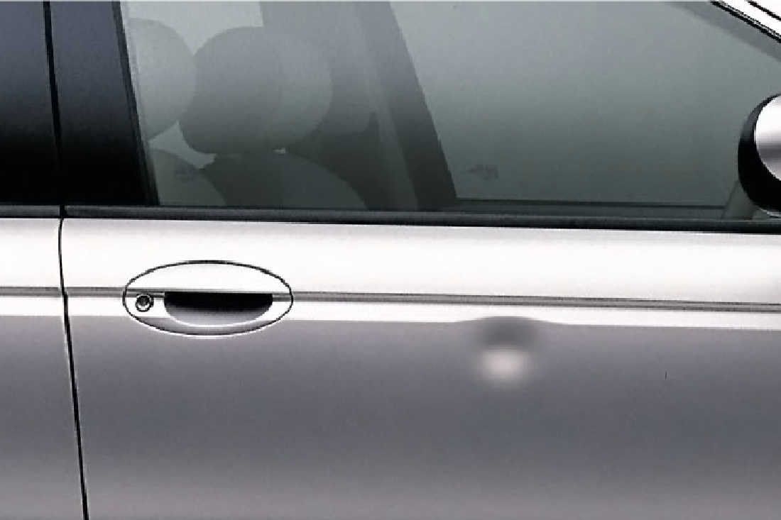 A silver car with a damaged door handle