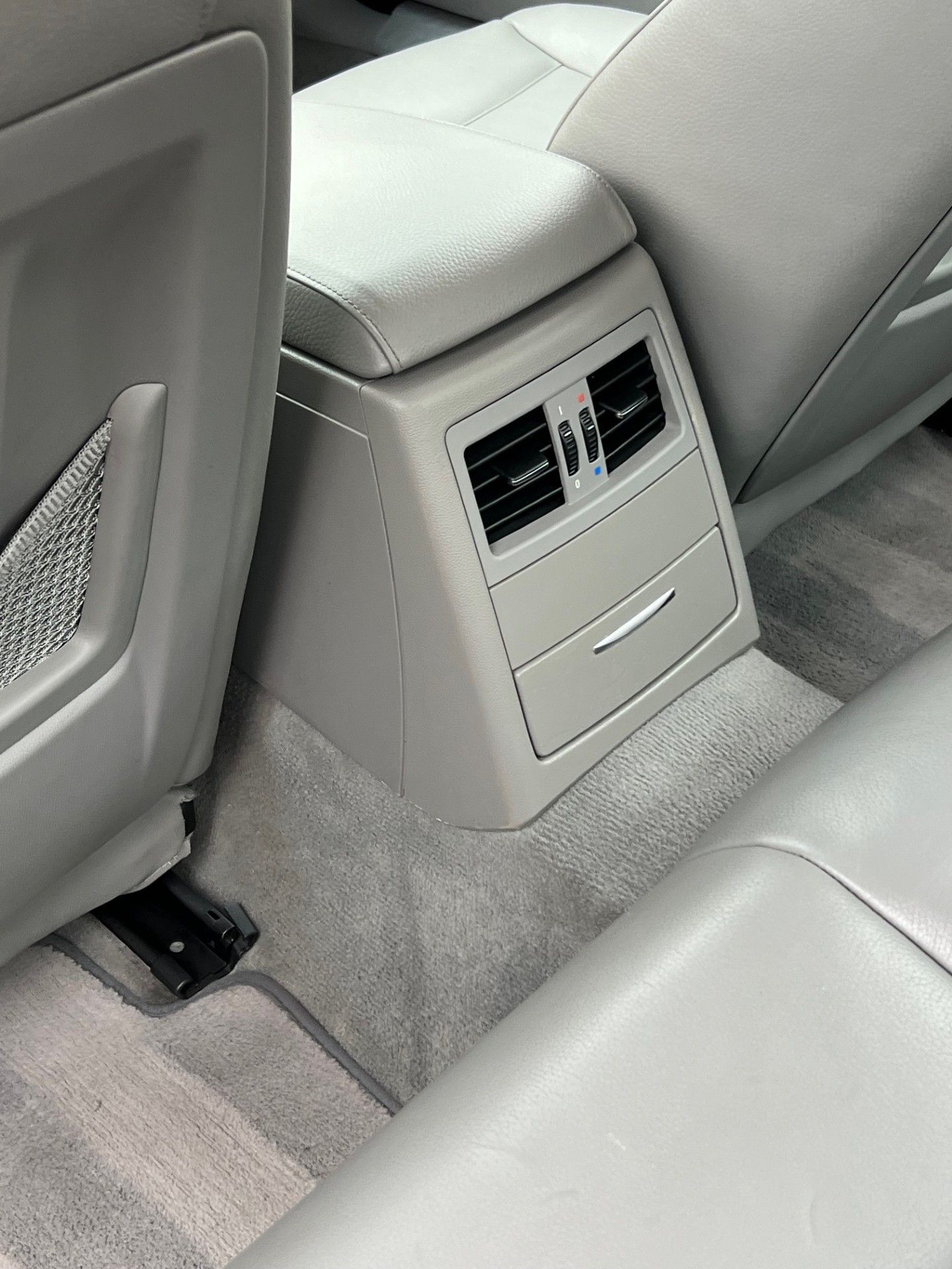 The back seat of a car with a rear air vent.