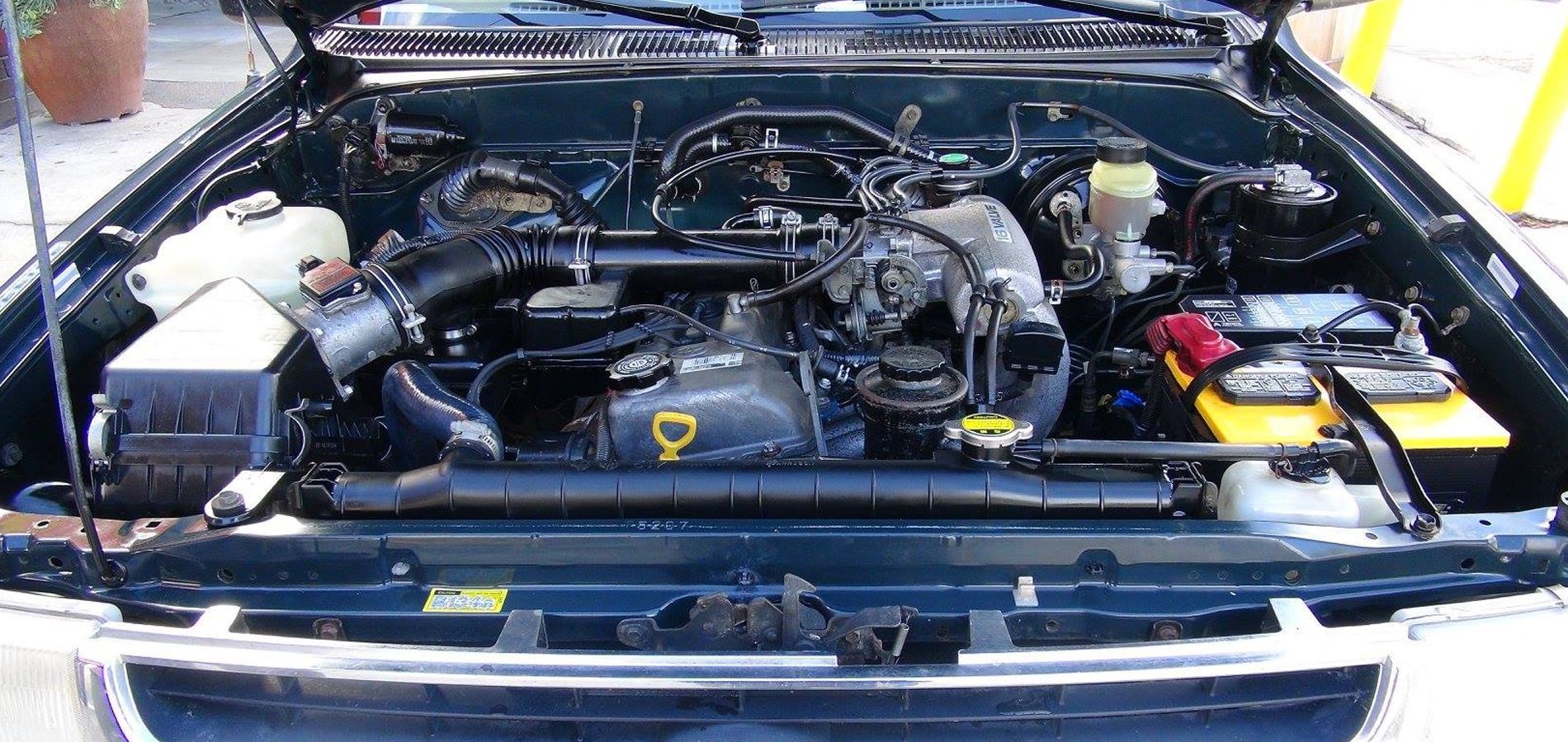 The engine of a car is shown with the hood open