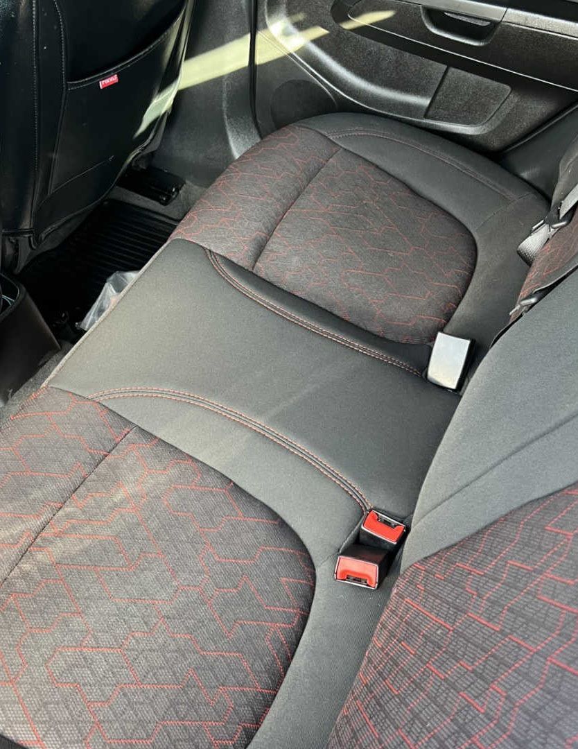 A close up of the back seat of a car with a seat belt.