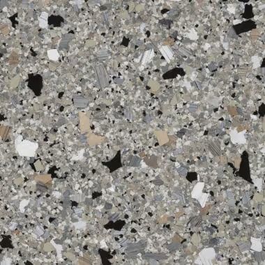 Close-up of a speckled floor tile. The pattern is primarily gray with black, white, and tan chips.