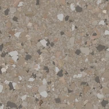 Close-up of a speckled floor. The chips are white, grey, and tan on a tan background.