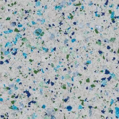 White speckled surface with blue and green glass flecks.