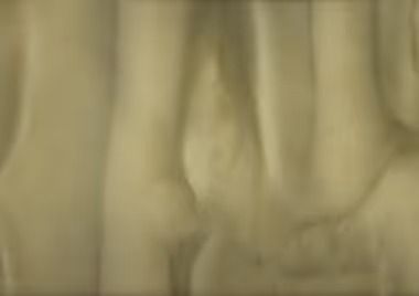 Cream-colored, textured fabric, possibly curtains, with soft folds and shadows.