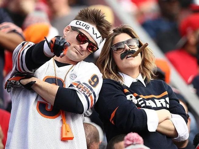 A man and a woman are standing next to each other in a stadium.