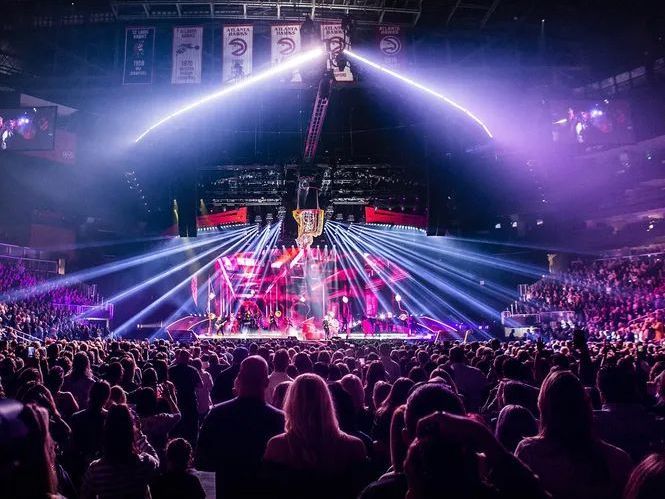 A crowd of people are watching a concert in a stadium.