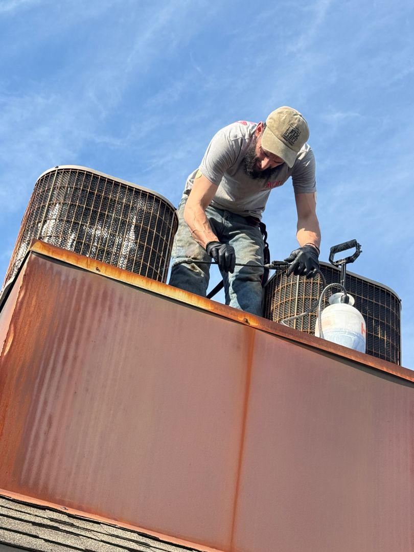 HVAC technician servicing an air conditioning unit to diagnose a leaking AC and condensate drain.