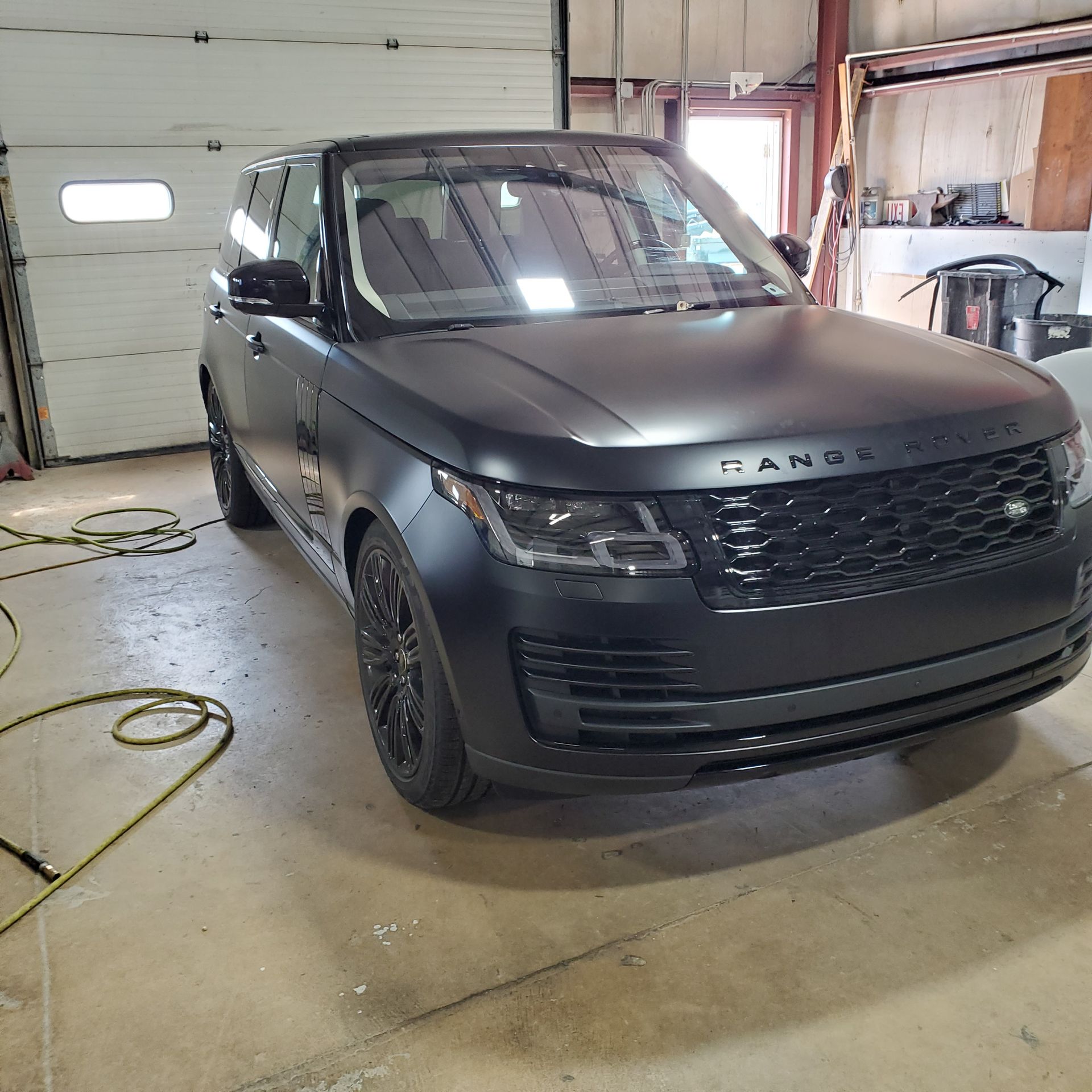 A black range rover is parked in a garage.