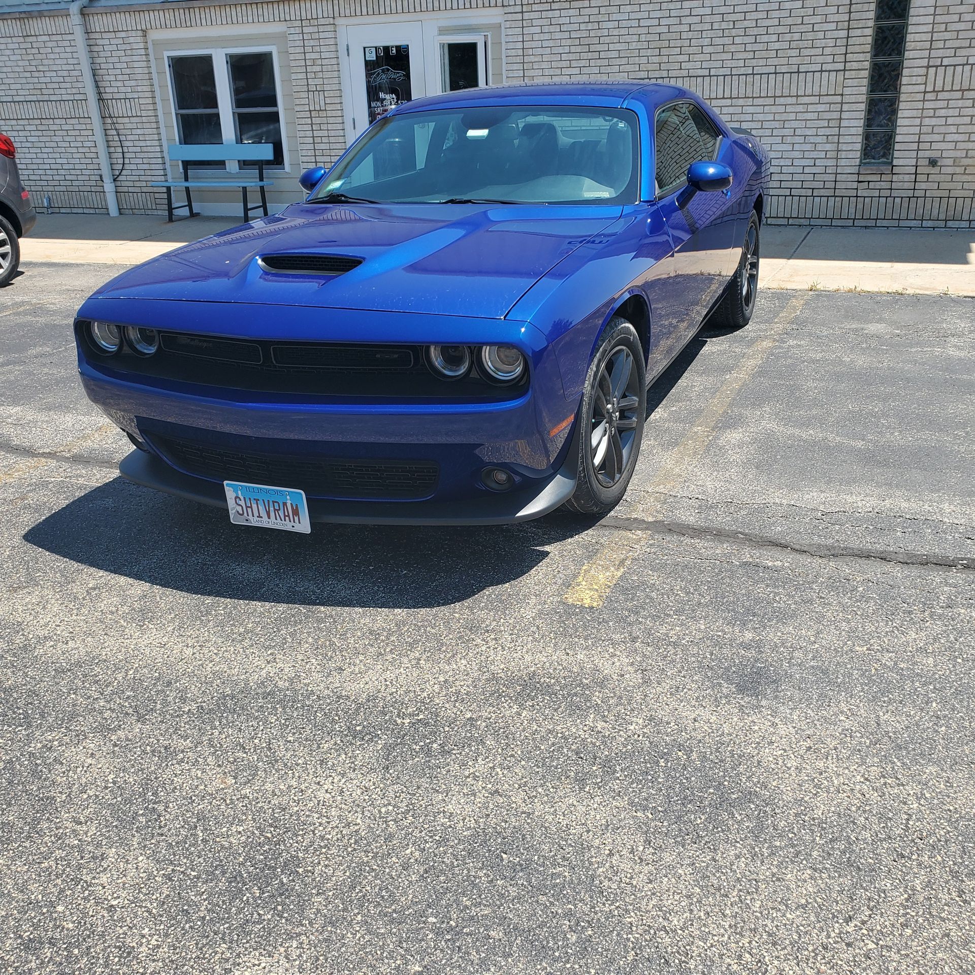 A blue dodge challenger is parked in a parking lot