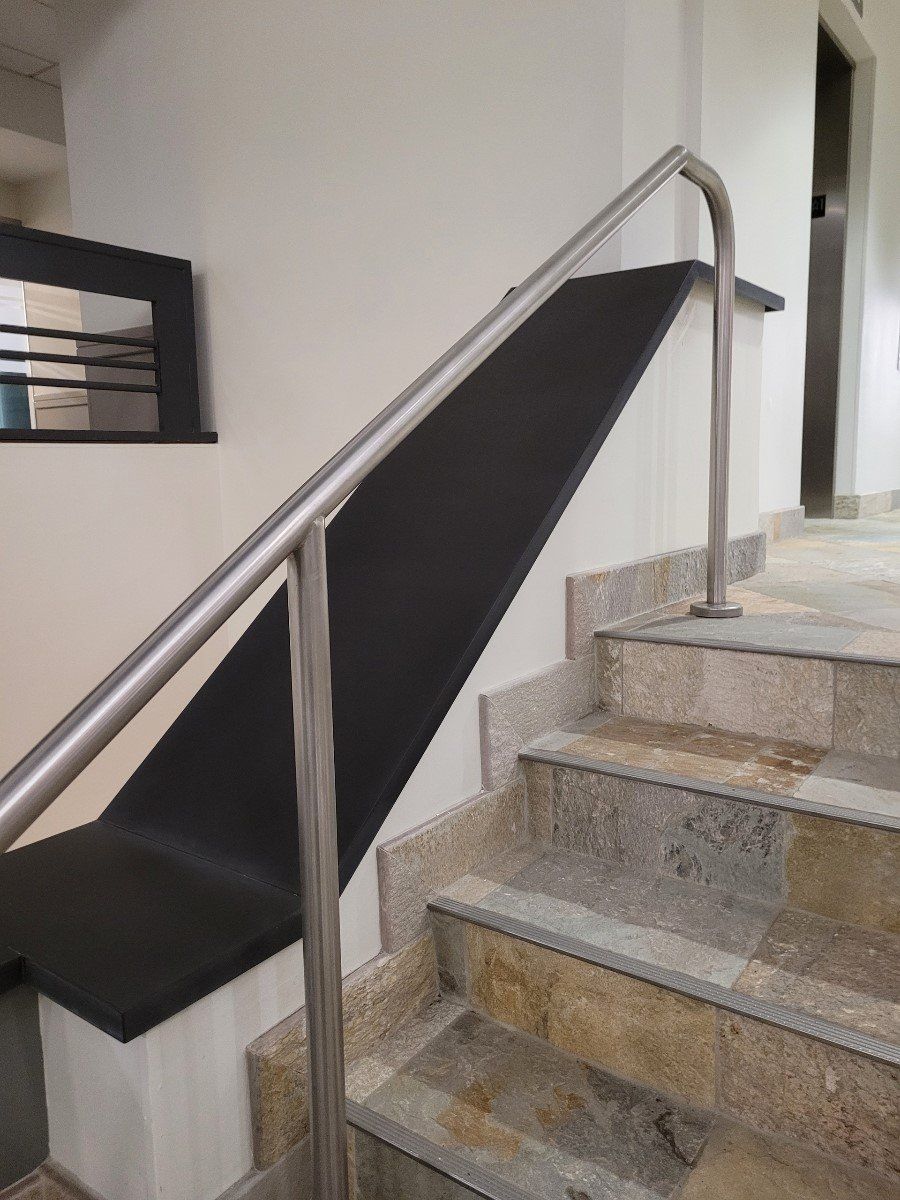 A staircase with a metal railing and a black step