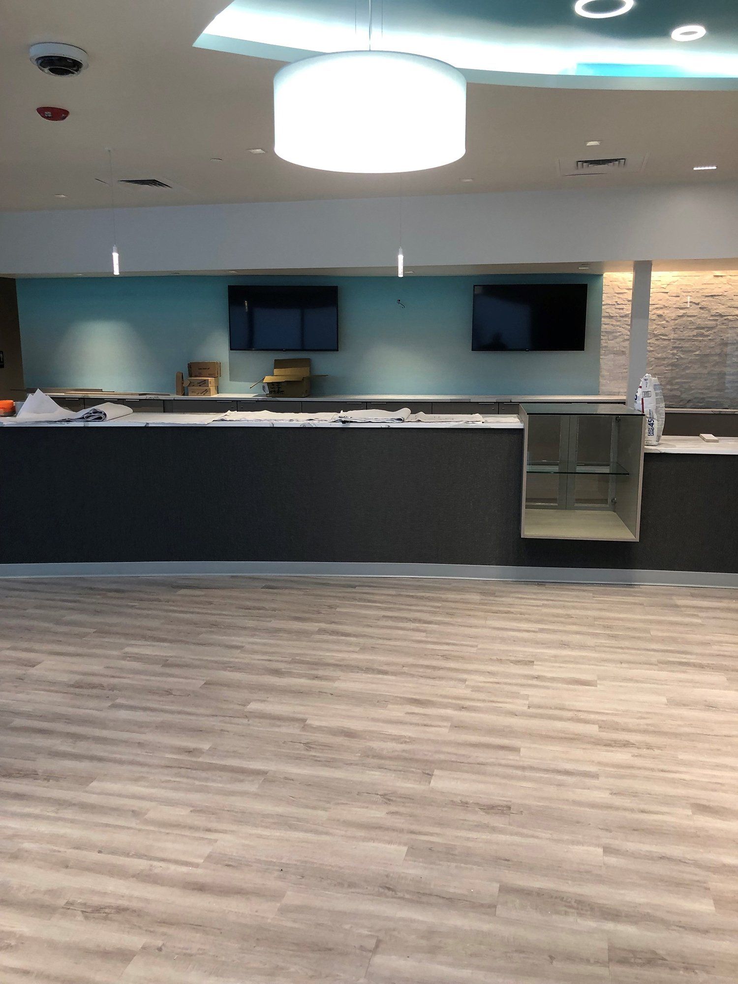 An empty room with a wooden floor and a counter