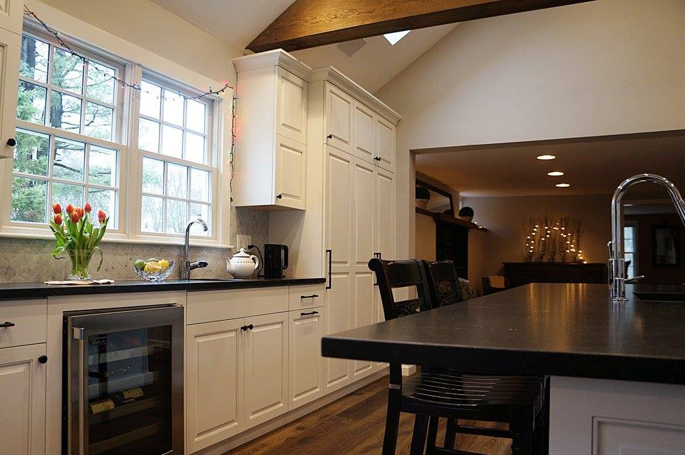 A kitchen with white cabinets and a black counter top