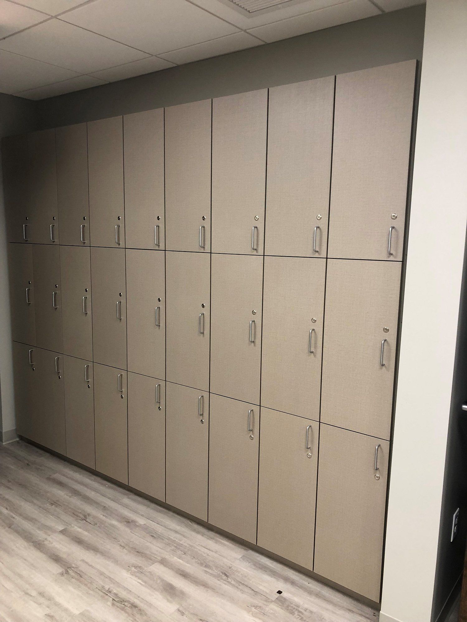 A row of lockers are lined up on a wall in a room.