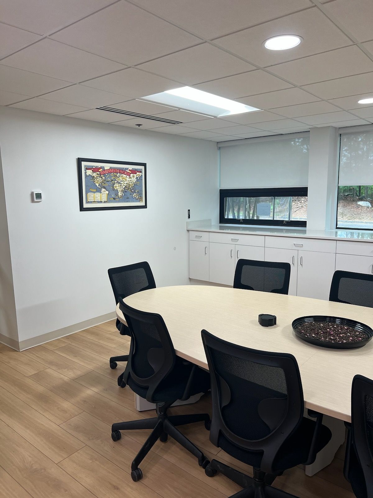 A conference room with a long table and chairs and a map on the wall.