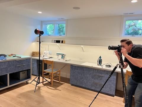A man is taking a picture of a room with a camera.