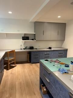 A kitchen with blue cabinets and a green counter top