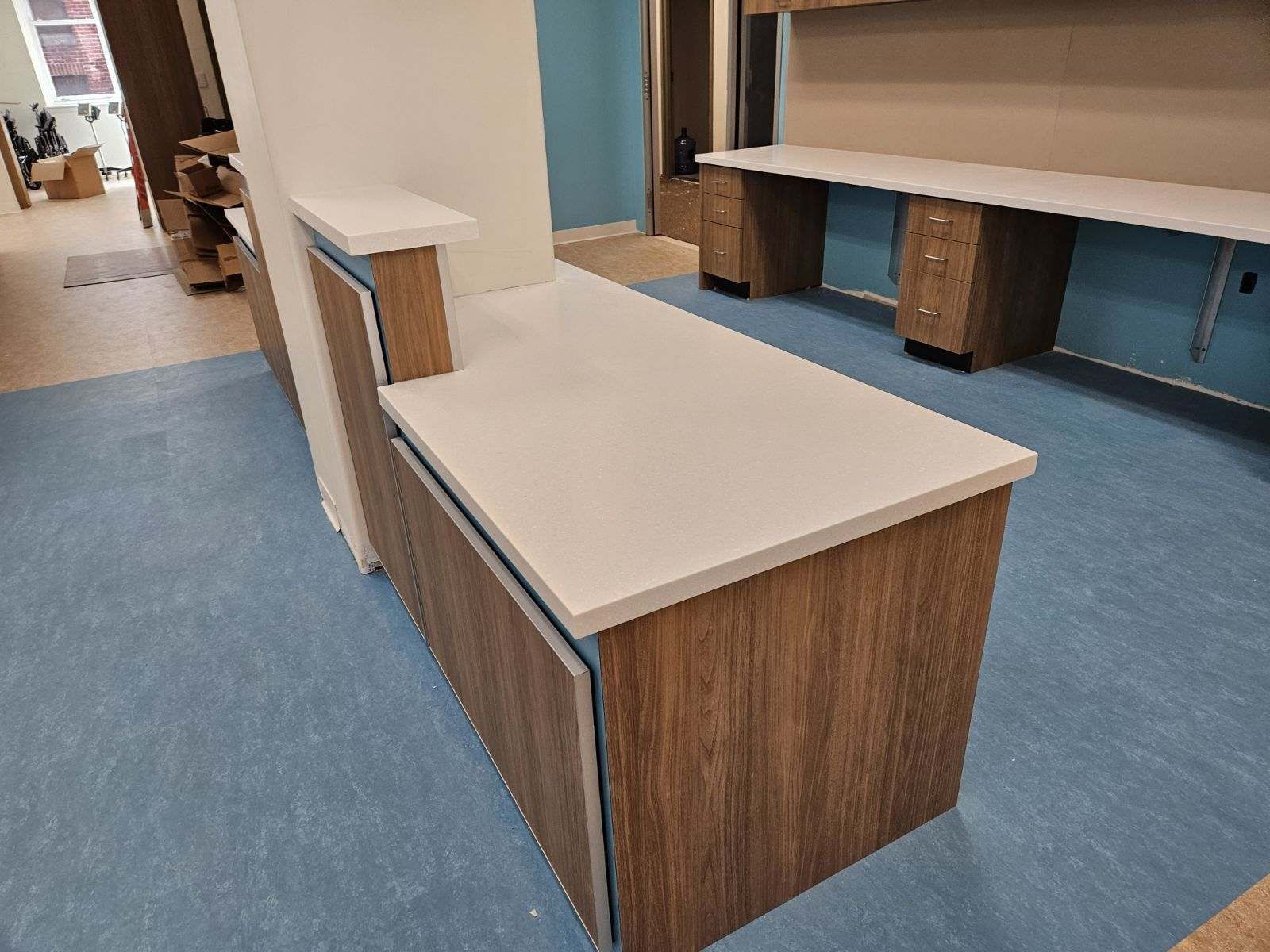 A large wooden table with a white counter top in a room.