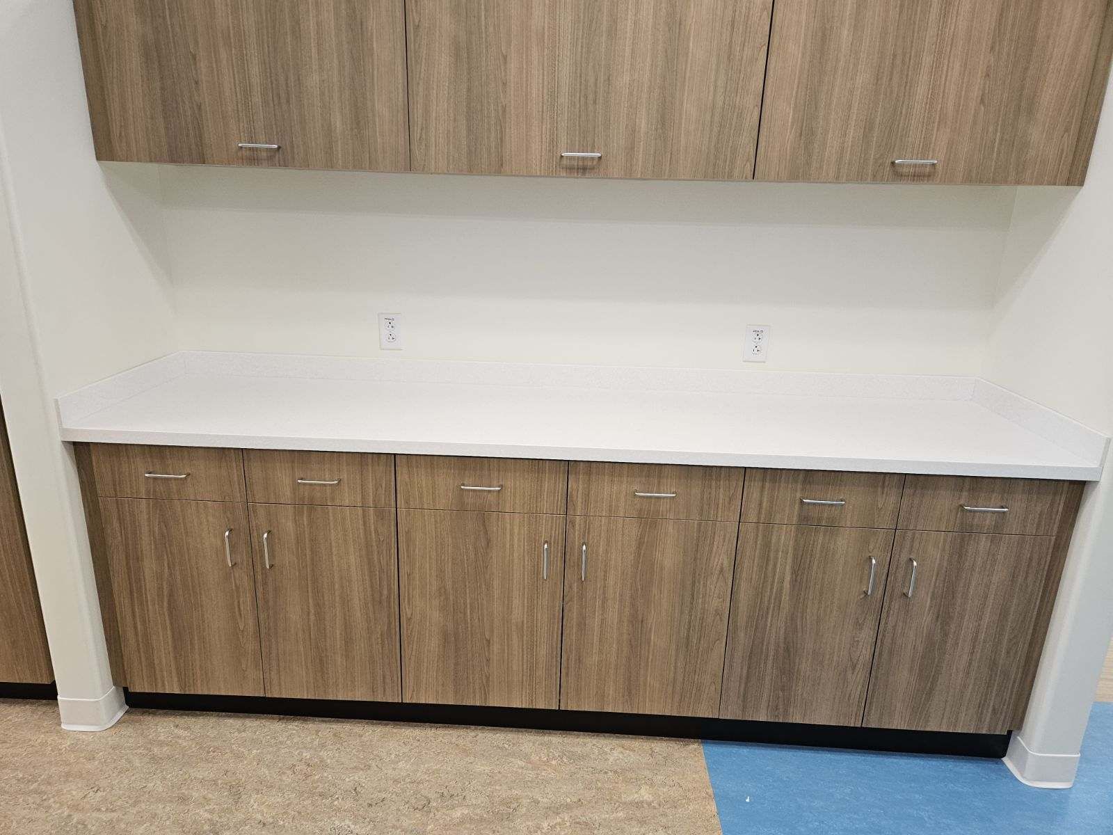 A kitchen with wooden cabinets and a white counter top.