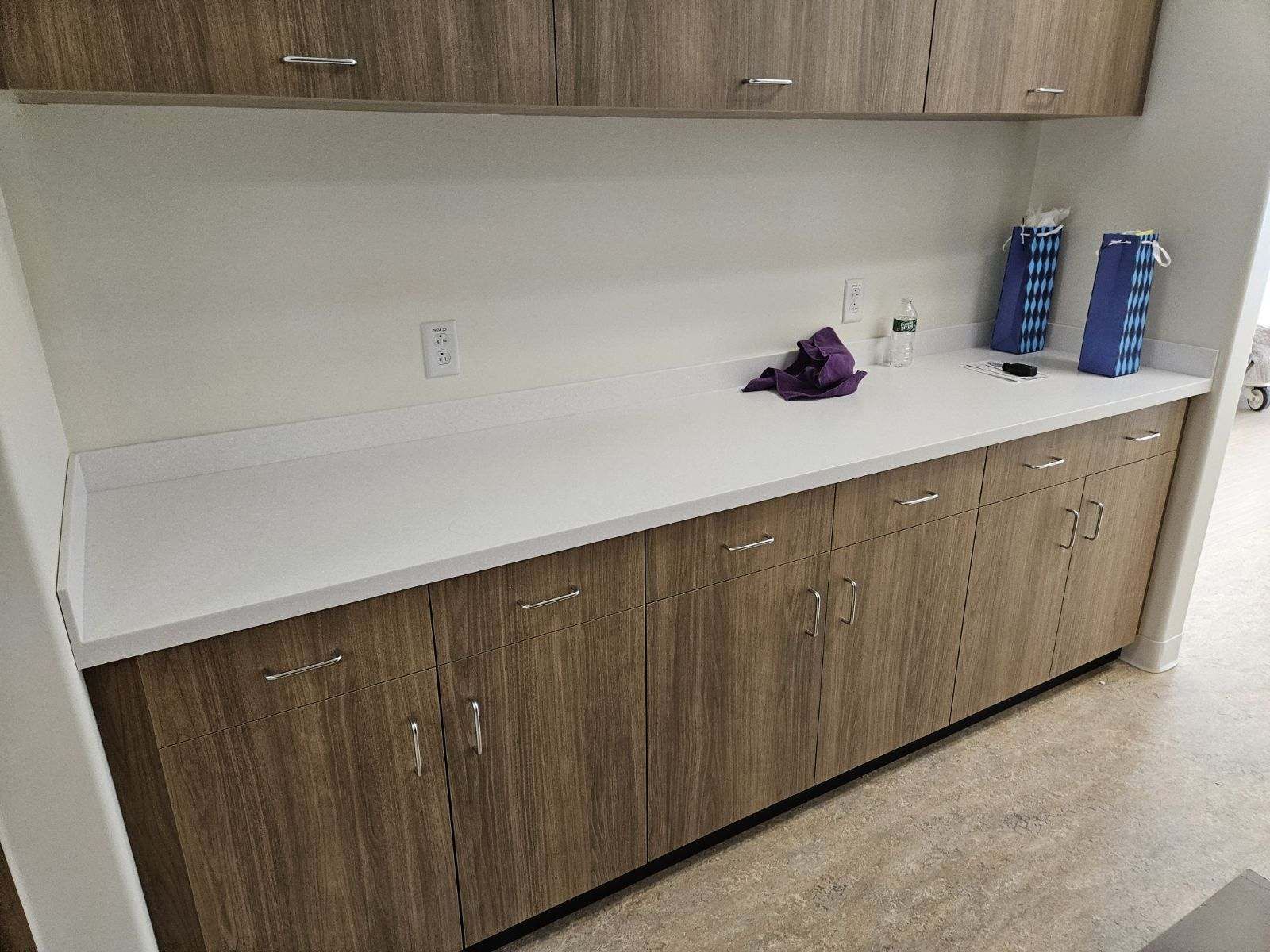A kitchen with wooden cabinets and a white counter top.