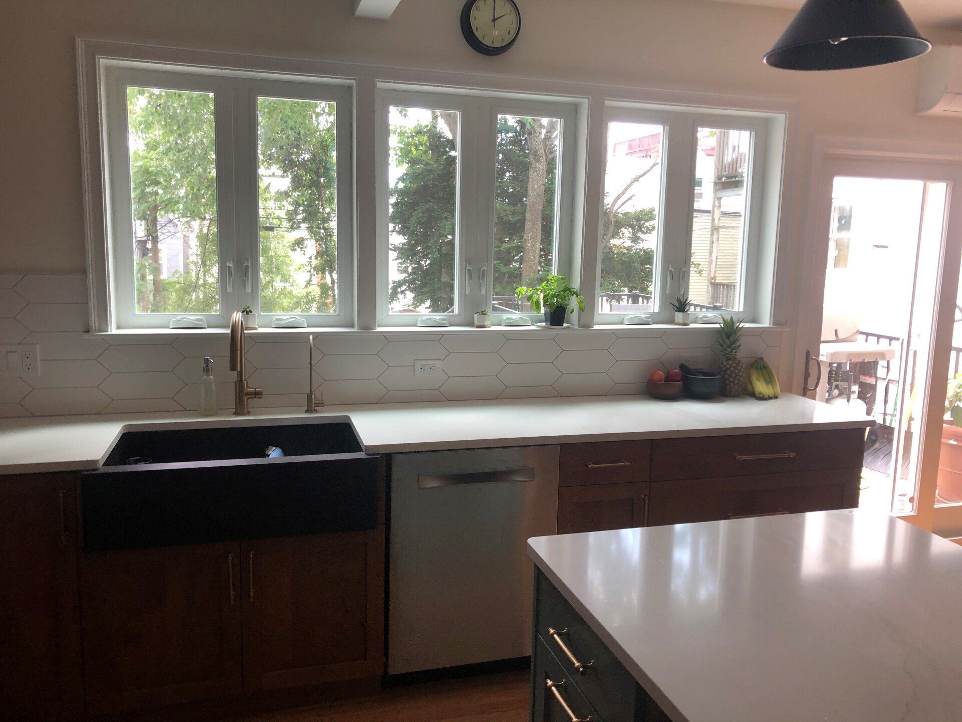 A kitchen with a sink and a clock on the wall