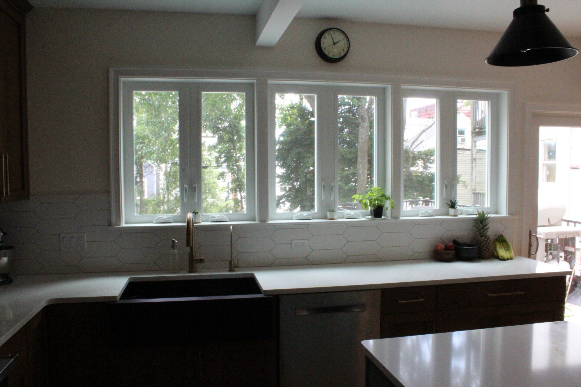 A kitchen with a sink and a clock on the wall