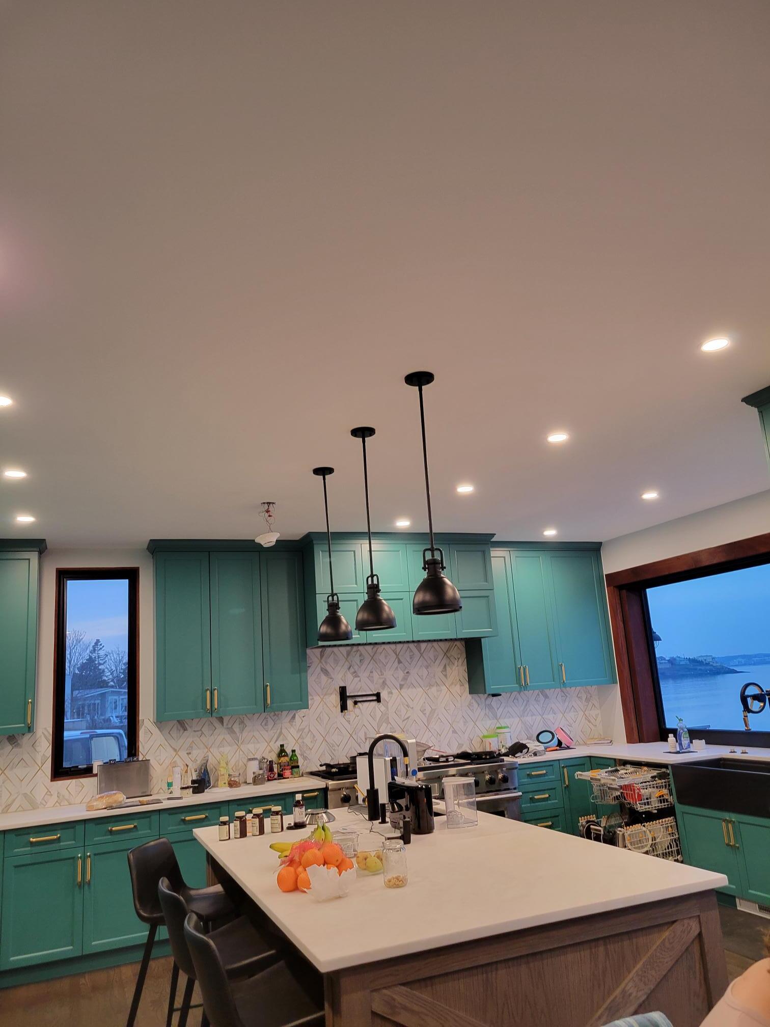 A kitchen with blue cabinets and a large island in the middle.