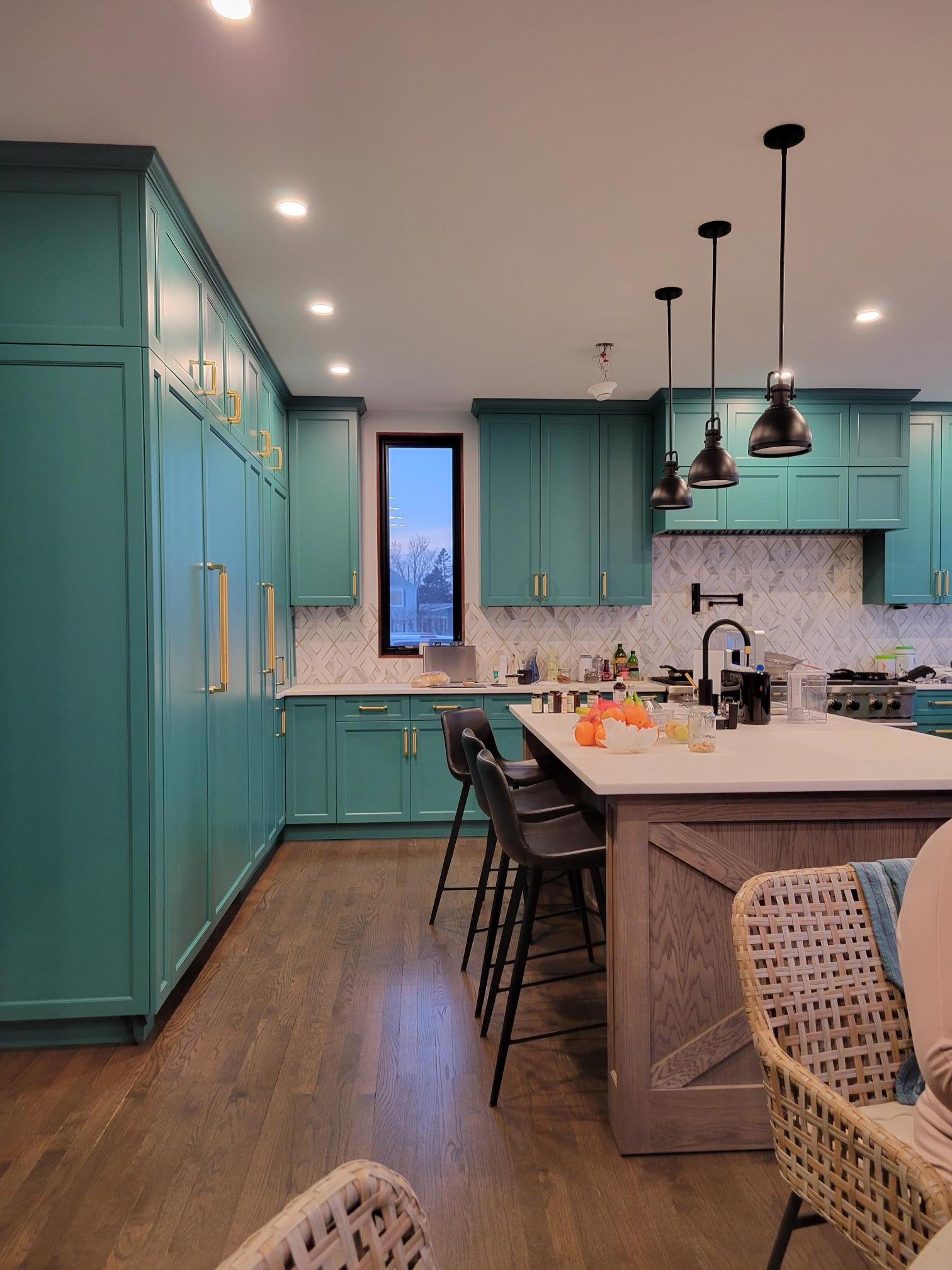 A kitchen with blue cabinets and a large island.