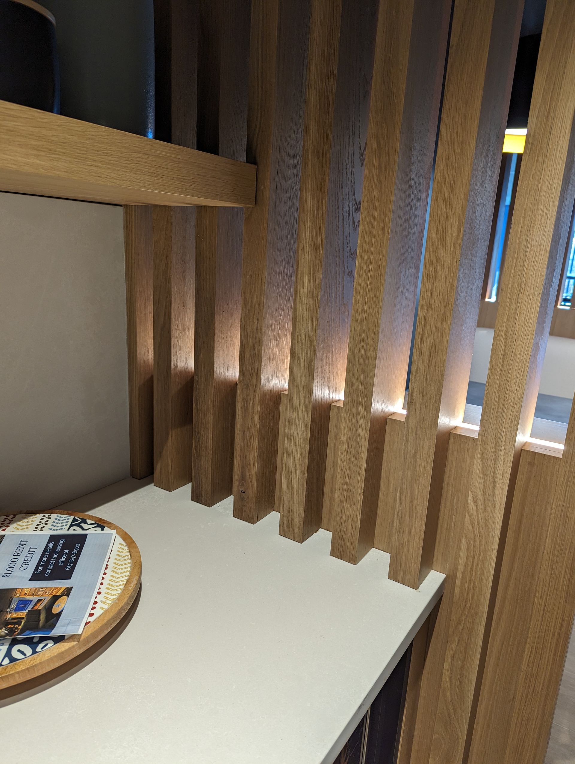 A wooden shelf with a tray on top of it in a room.
