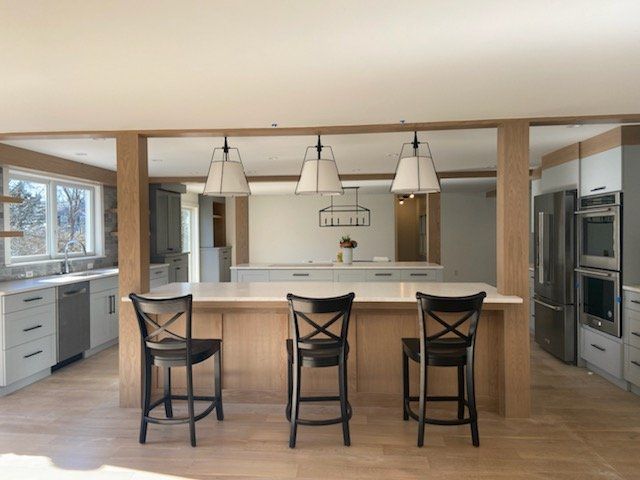 A kitchen with a large island and three chairs