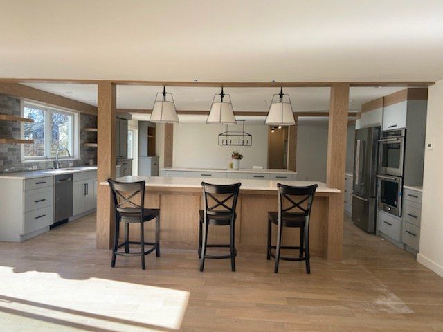 A kitchen with a large island and three chairs