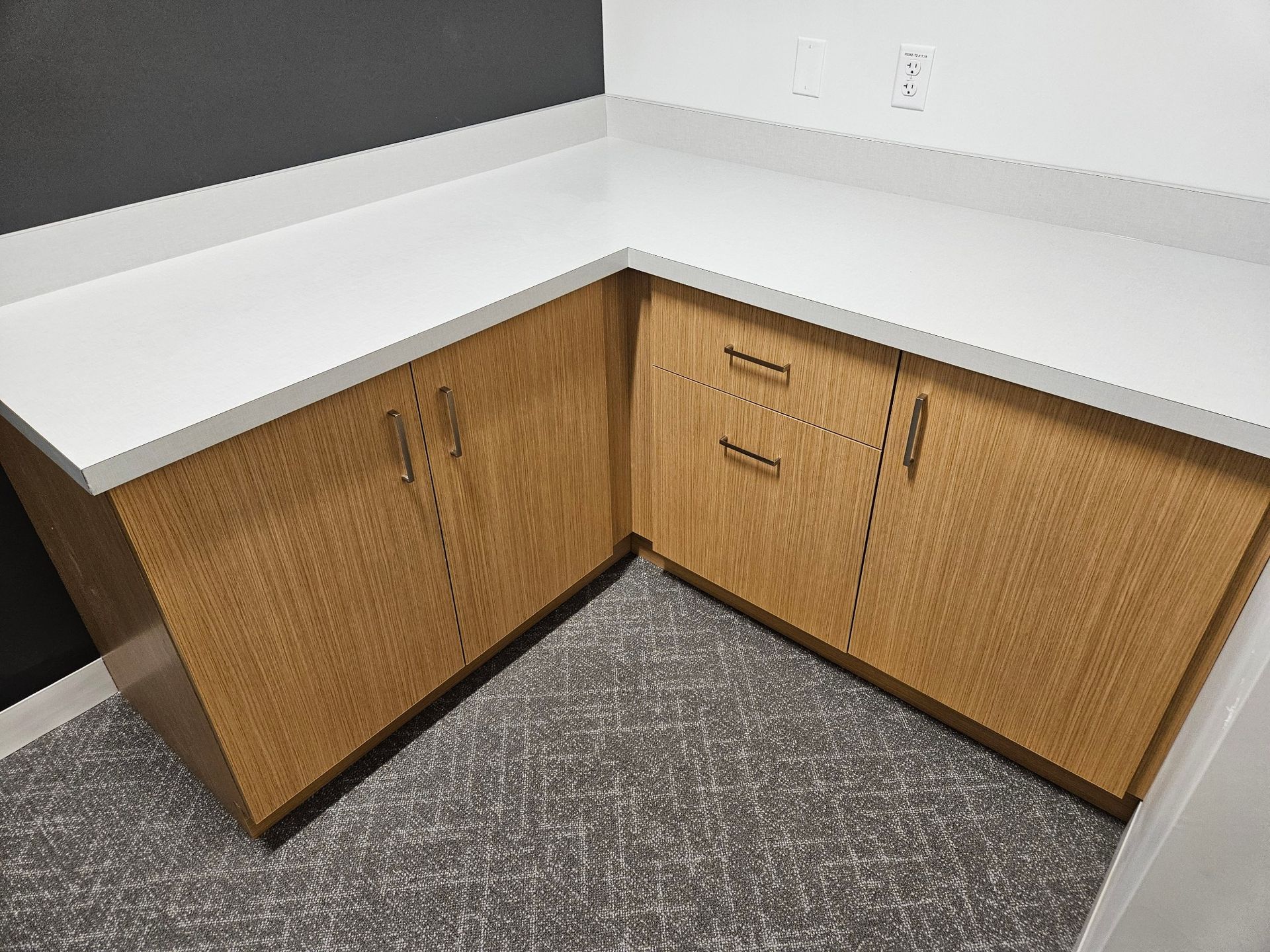 A kitchen with wooden cabinets and a white counter top.