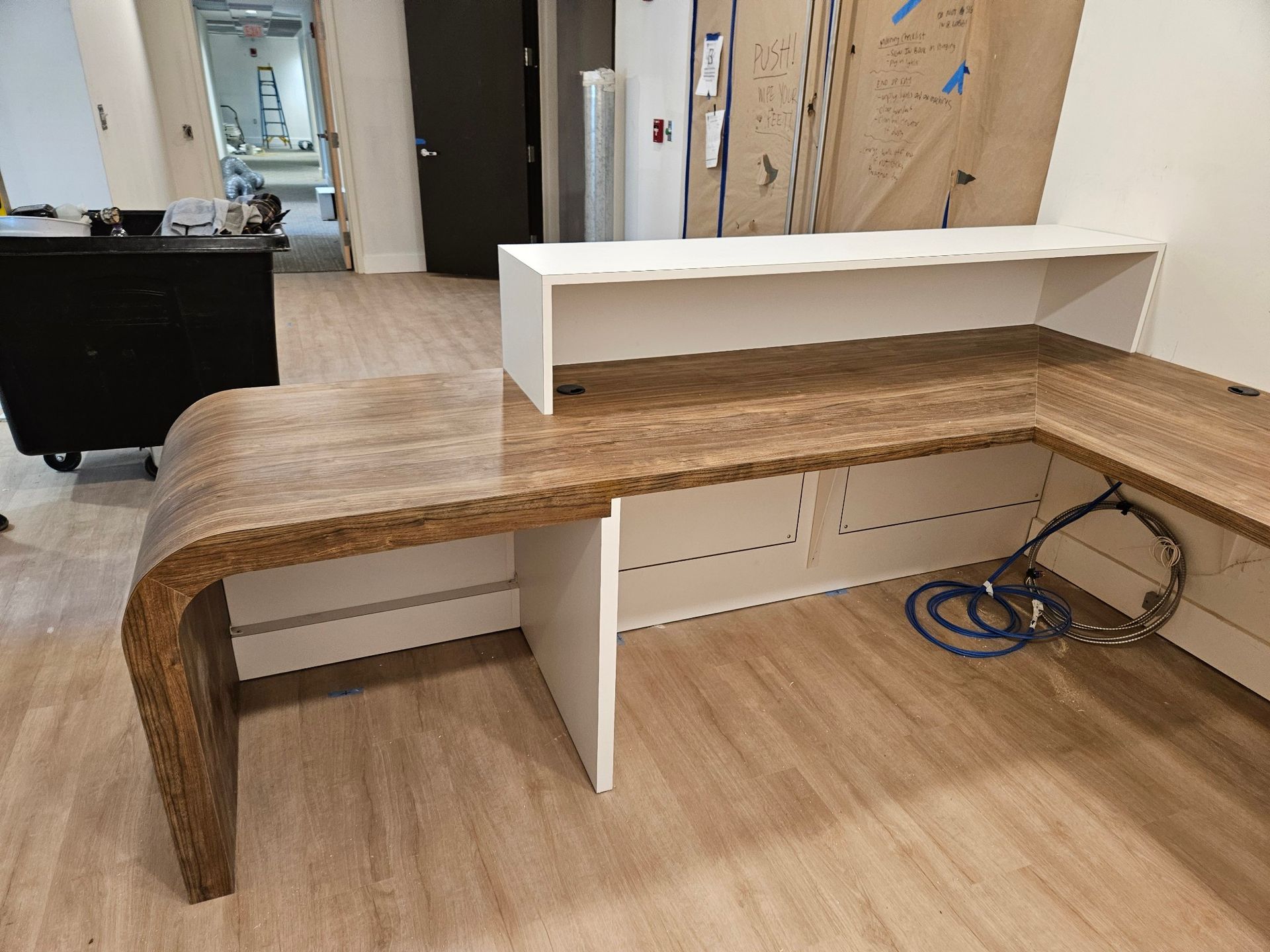 A desk with a wooden top is sitting on a wooden floor in a room.