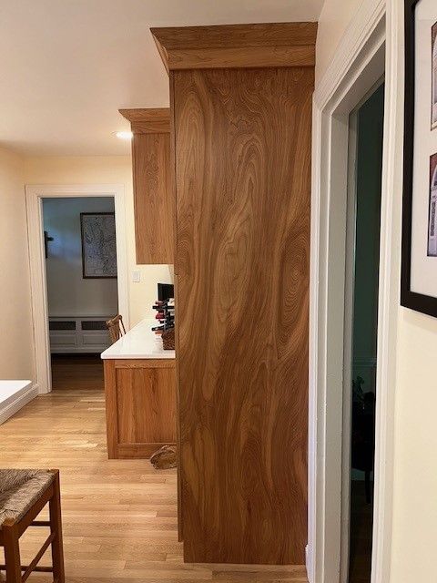 A kitchen with wooden cabinets and hardwood floors.