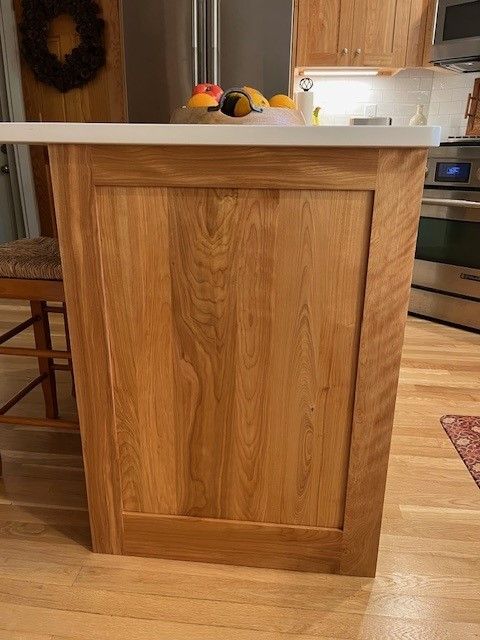 A wooden island in a kitchen with fruit on it