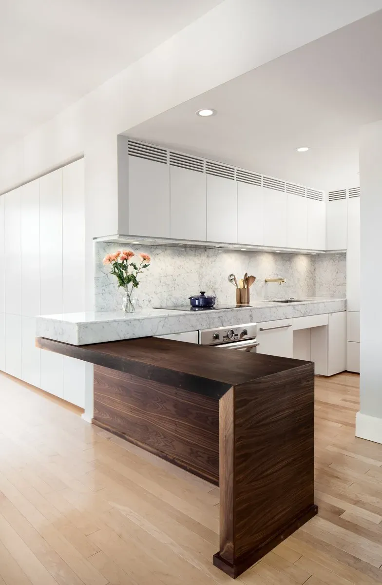 A kitchen with a wooden island and white cabinets
