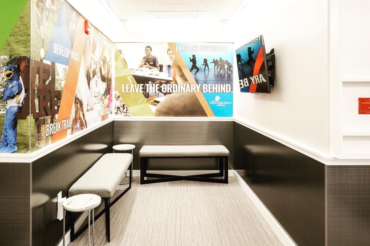 A waiting room with a bench and a mural on the wall.