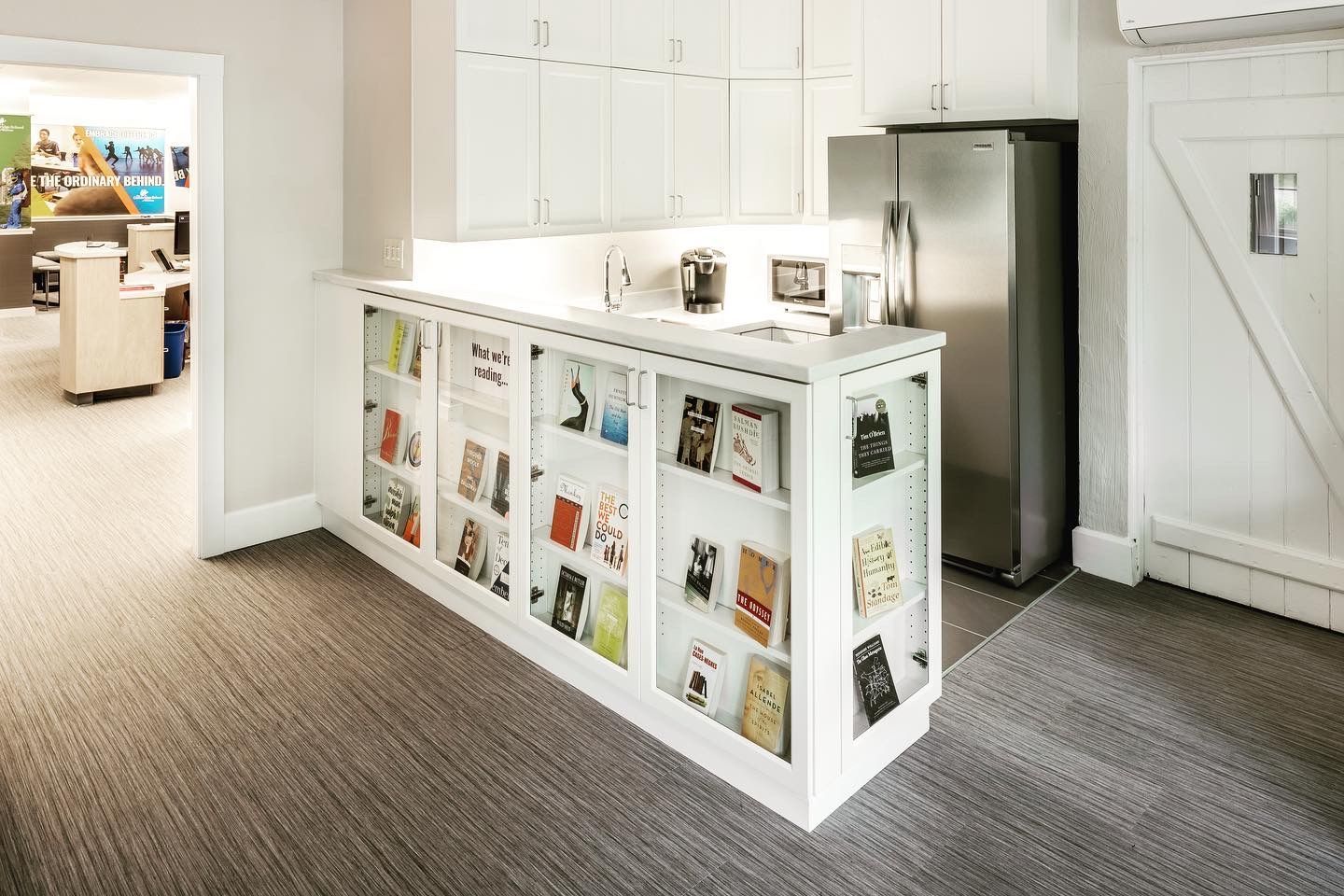 A kitchen with a refrigerator and a counter with books on it