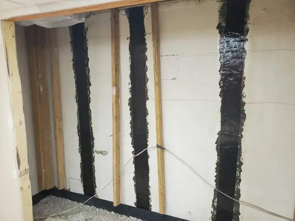 A room with a wooden frame and a white wall with black stripes on it.